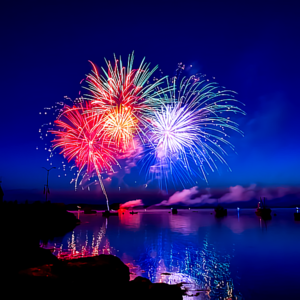 fireworks in the sky over water - New Year’s Eve Fireworks Safety